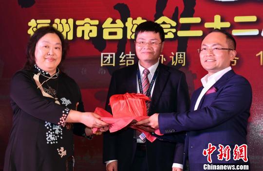 新当选福州市台胞投资企业协会第11届会长陈奕廷(右一)与福州市台胞投资企业协会第10届会长陈秀容(左一)举行交接仪式。　记者刘可耕 摄